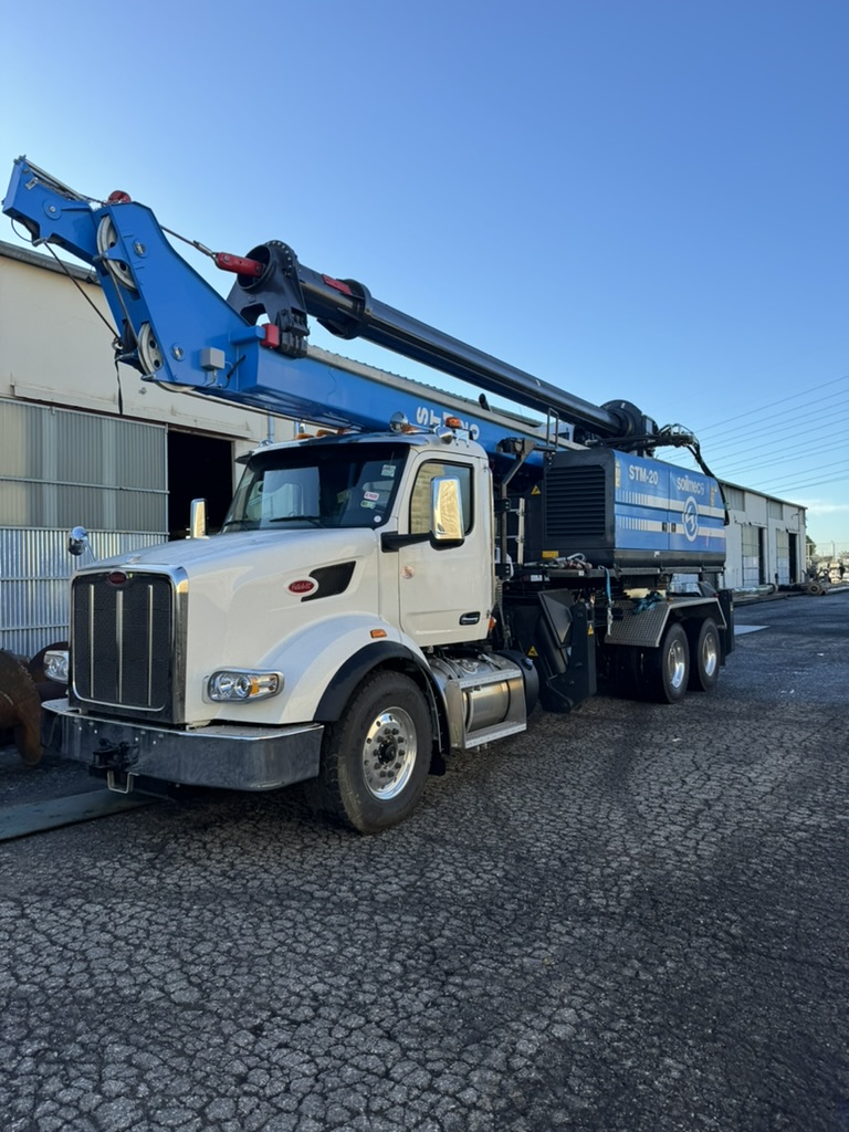 A truck with a crane on top, used for equipment solutions and foundation drilling.