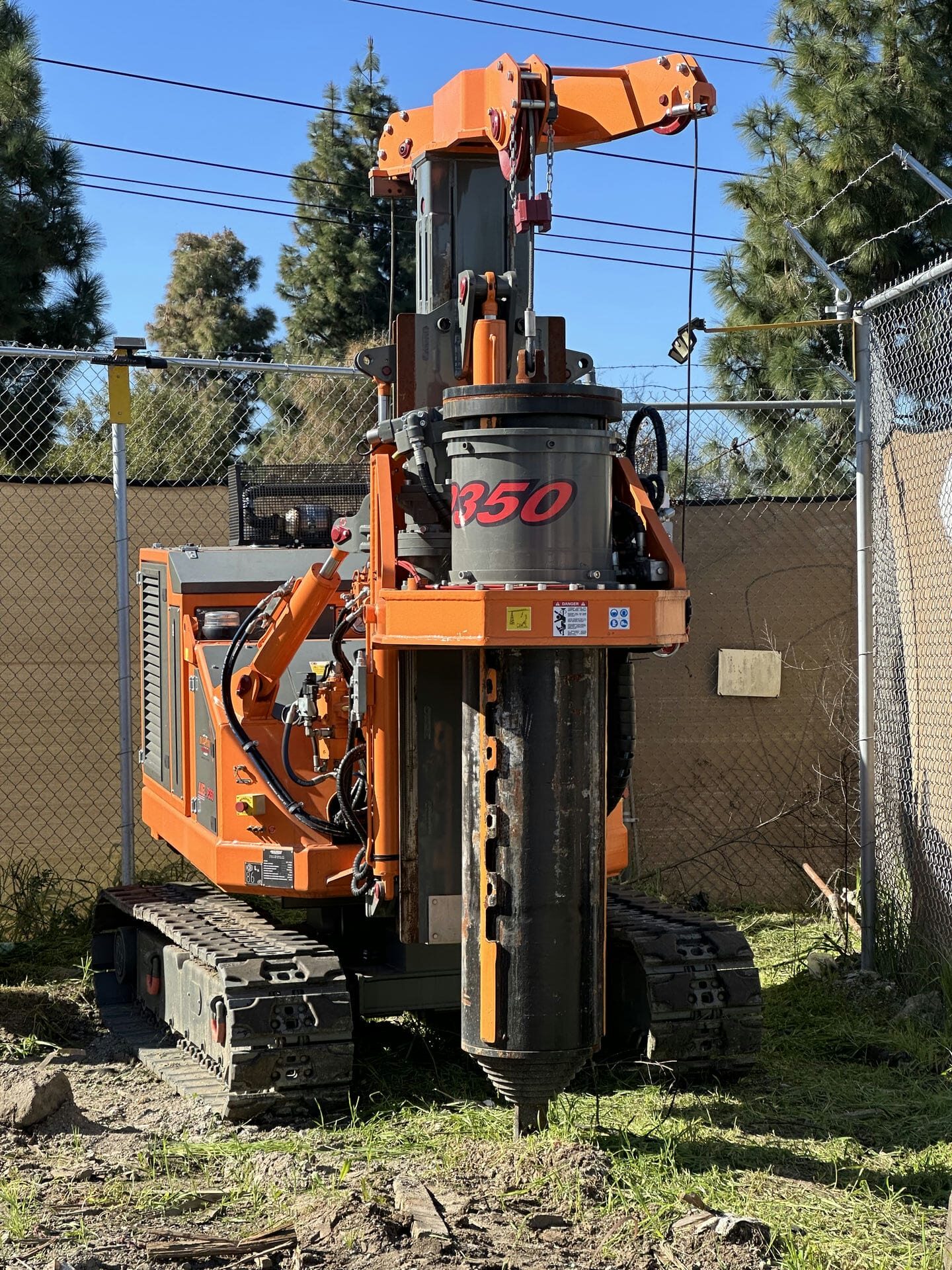 A small orange backhoe machine parked on the ground.