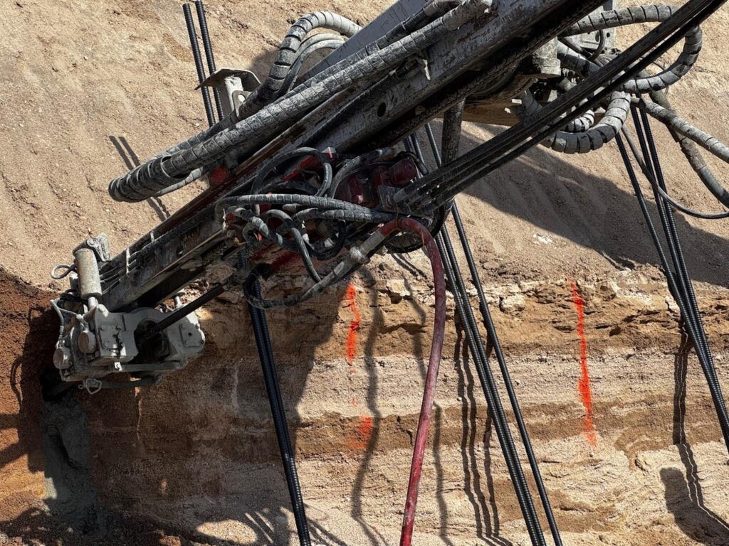 A heavy machinery is actively digging a large hole in the earth