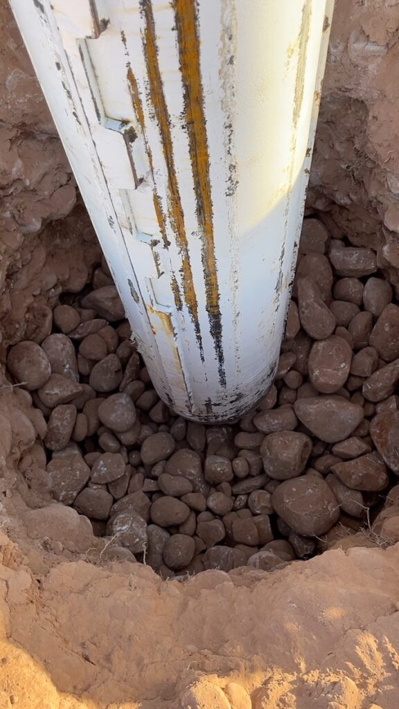 A large white pipe with rocks in the ground. Used for drilling, drilled shafts, and driven piles