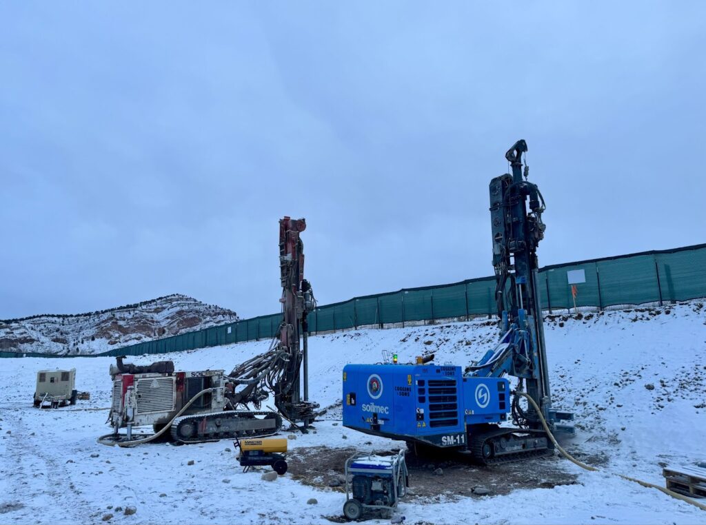 Drilling rigs on snowy hillside, showcasing drilling equipment in construction setting