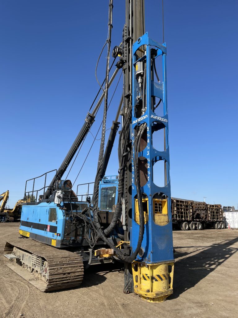 Blue Junttan PM16 Piling Rig with HHK 4SL Hydraulic Impact Hammer on dirt field